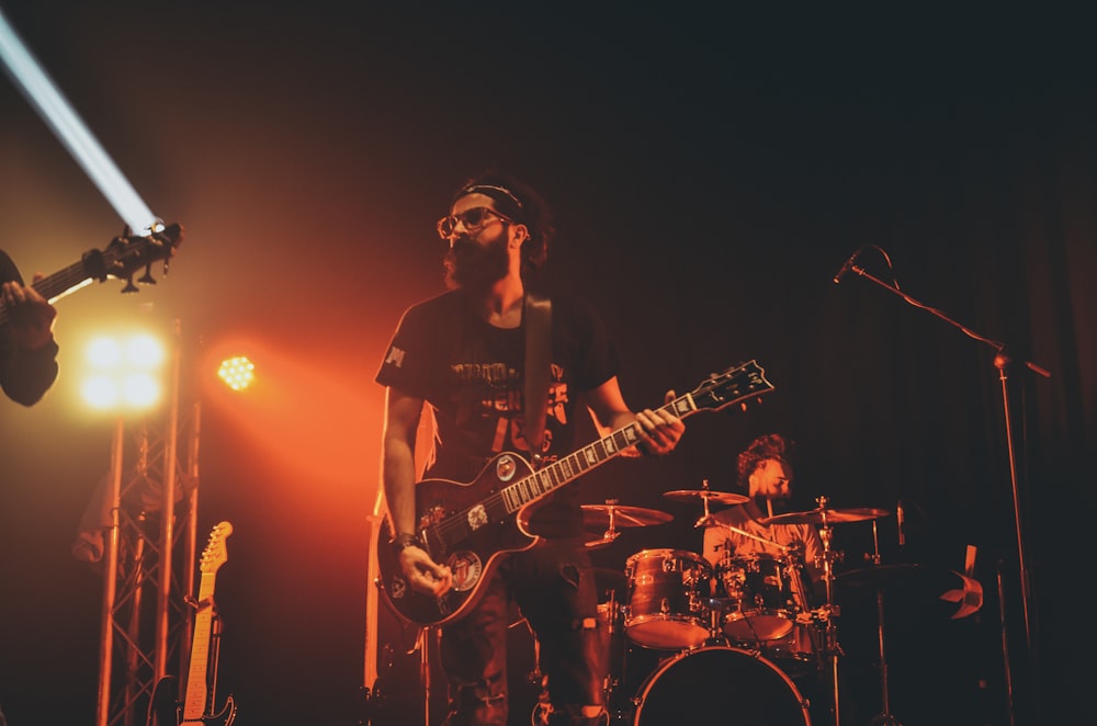 man in black crew neck t-shirt playing electric guitar