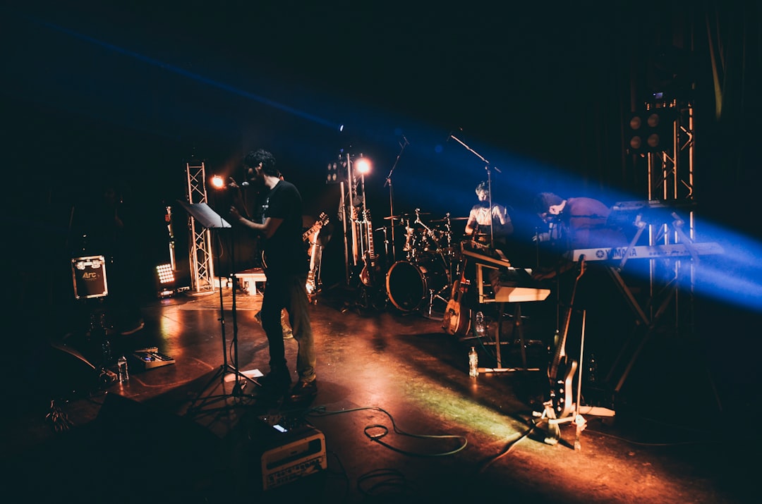 man in black t-shirt playing guitar on stage