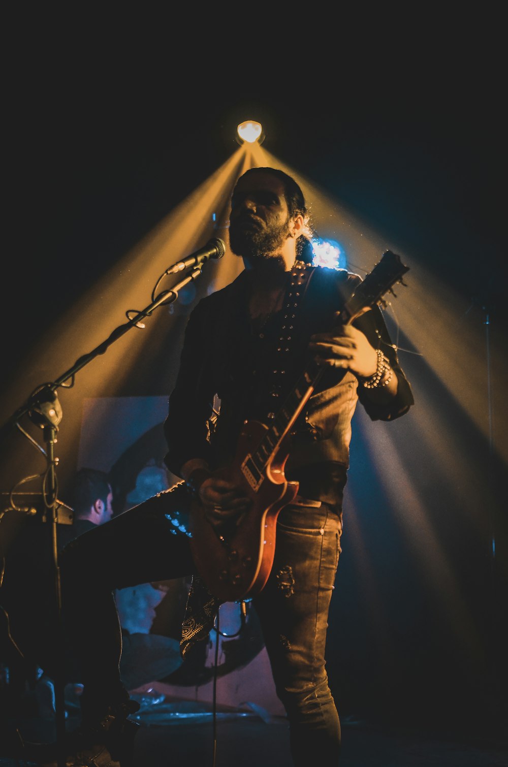 Mann in schwarzer Jacke spielt Gitarre