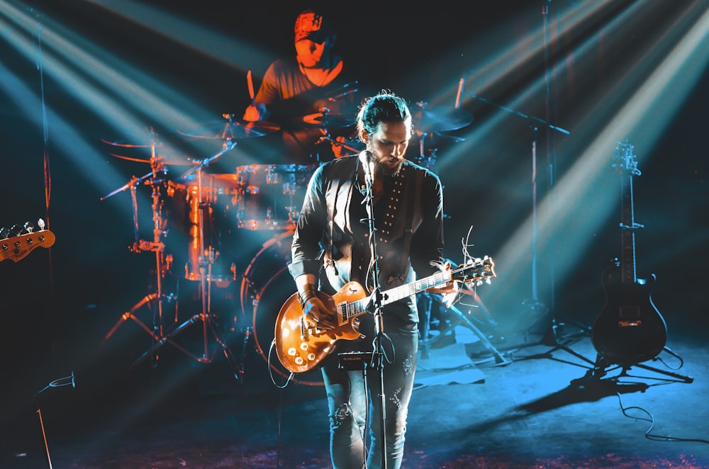 man in black leather jacket playing guitar