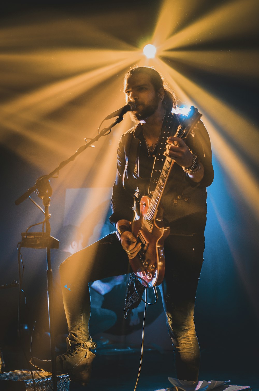 man in black shirt singing on stage