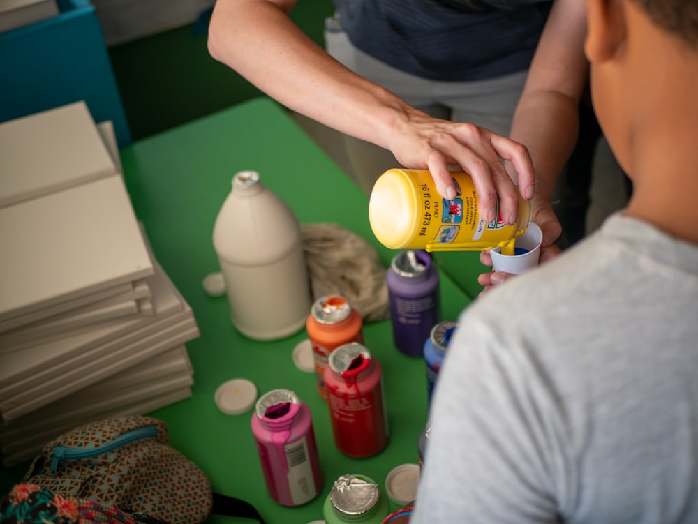 person holding yellow and blue plastic bottle