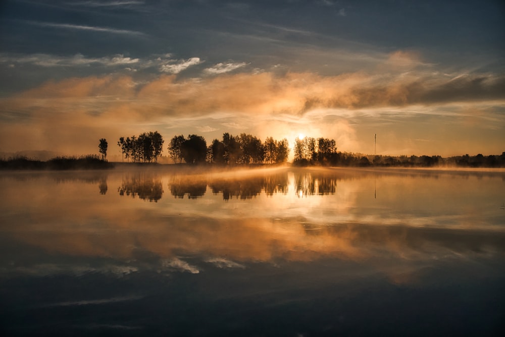 body of water near trees under blue sky during daytime