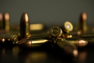 silver and gold bullet on brown wooden table