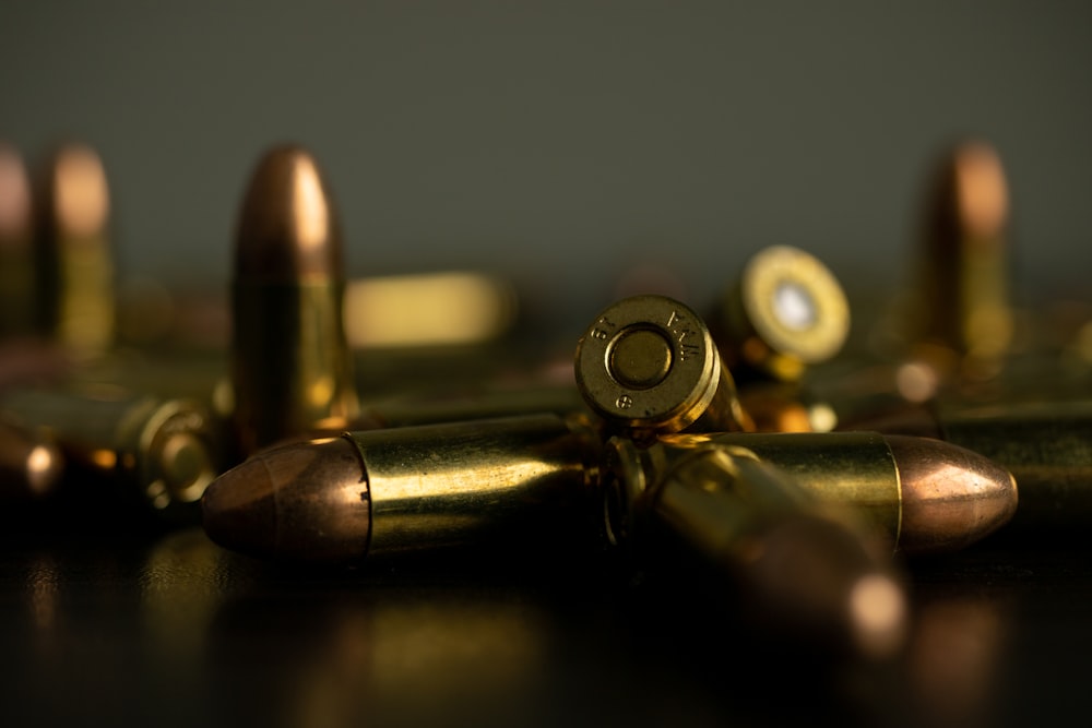 silver and gold bullet on brown wooden table