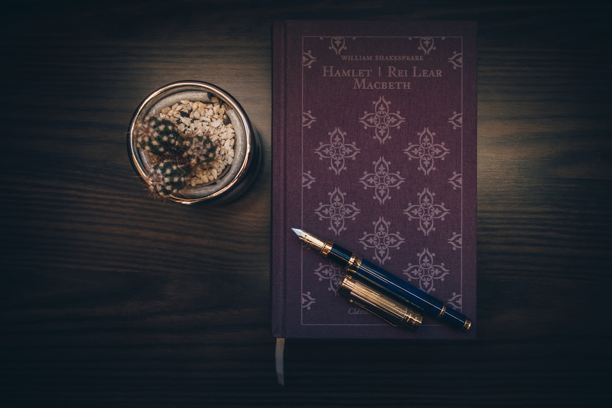 An open journal and pen beside a flickering candle in warm low light