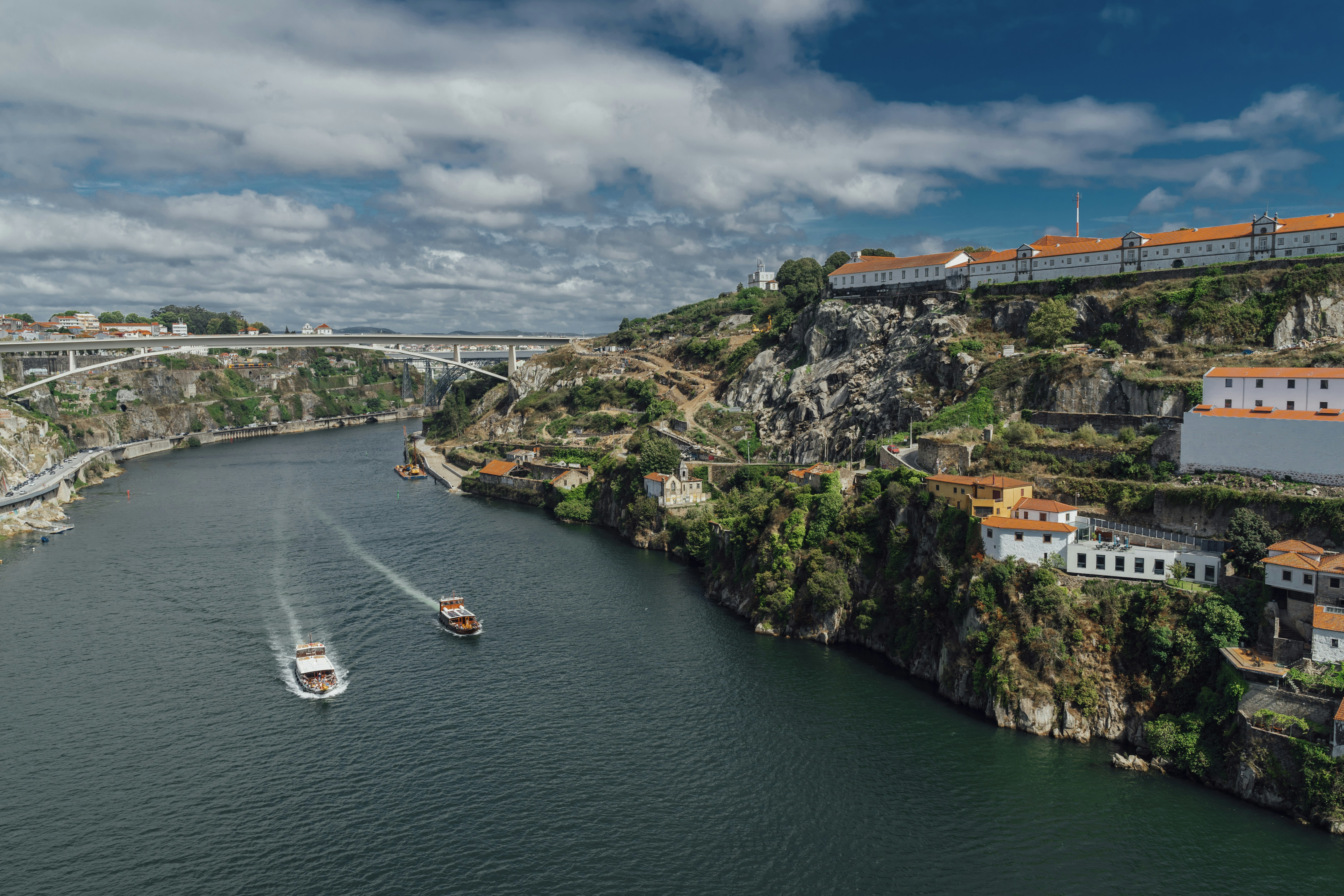 white boat on river near green trees under cloudy sky during daytime