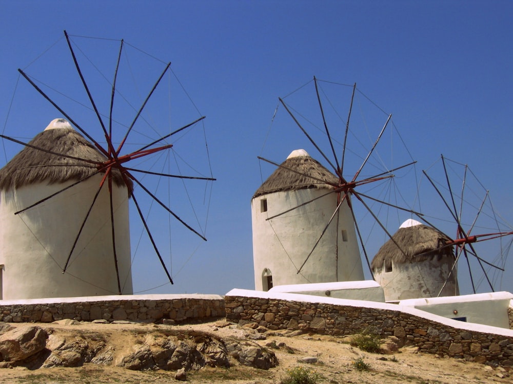 white windmill on brown field under blue sky during daytime