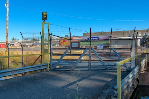 Close-up view of a fenced industrial plot with signage displaying plot number and size.