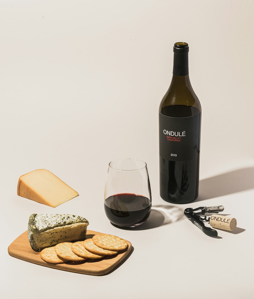 clear glass bottle beside bread and bread on white table