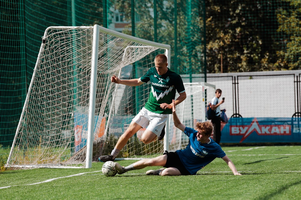 Mann im blau-weißen Fußballtrikot kickt tagsüber auf grünem Rasen