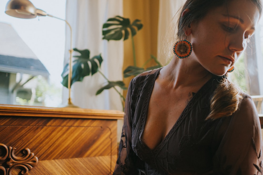 a woman in a black dress looking down at her cell phone