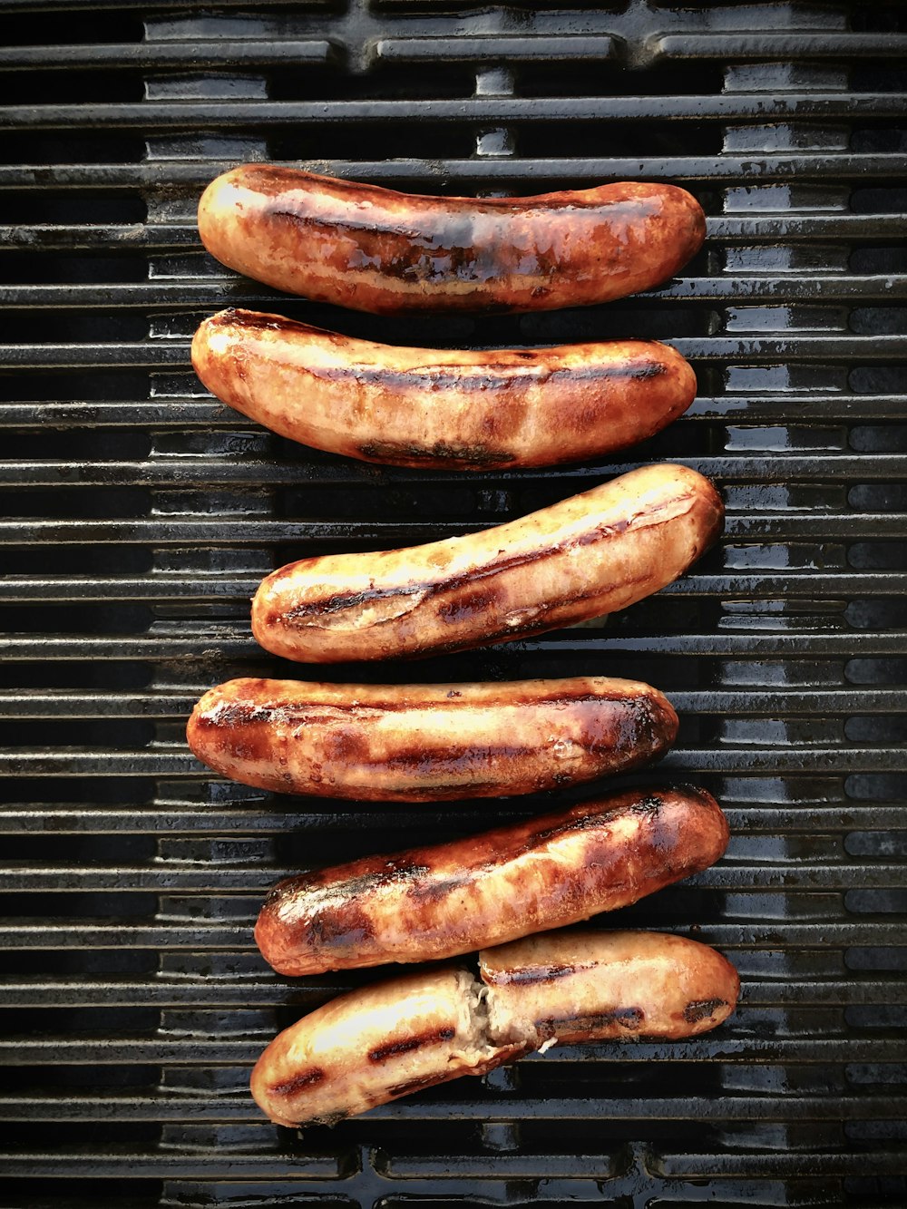 salsiccia marrone su griglia di metallo nero