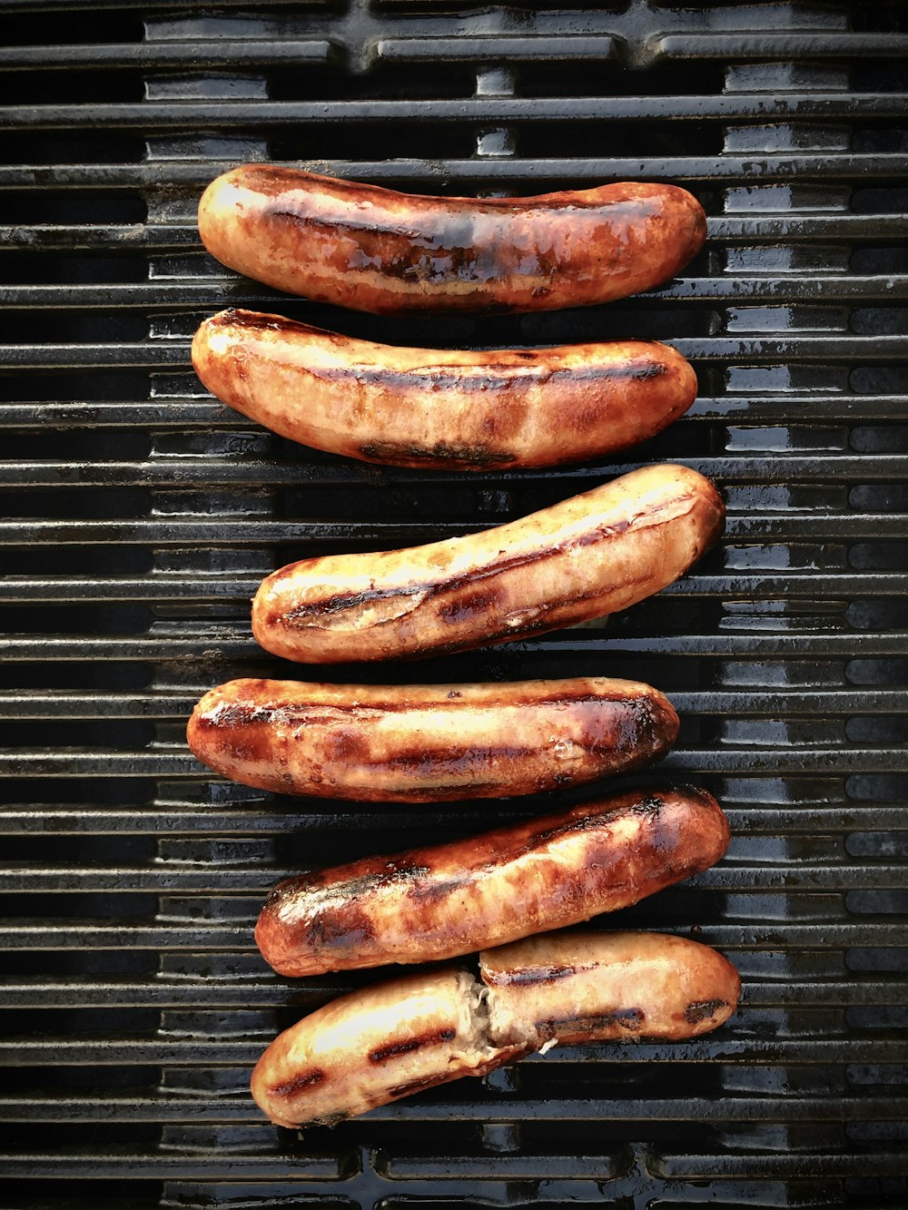 brown sausage on black metal grill