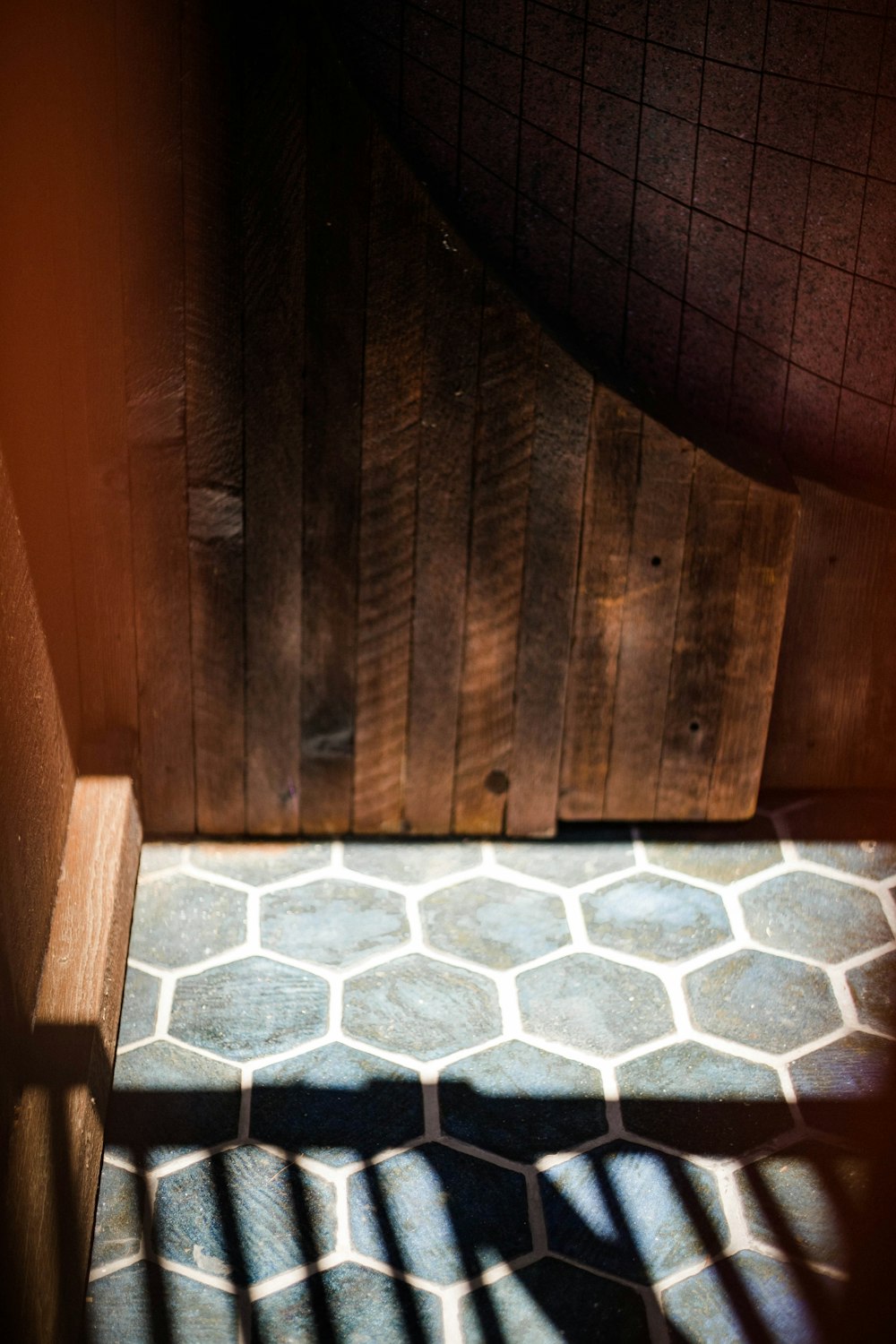 brown wooden wall with white and gray floor tiles