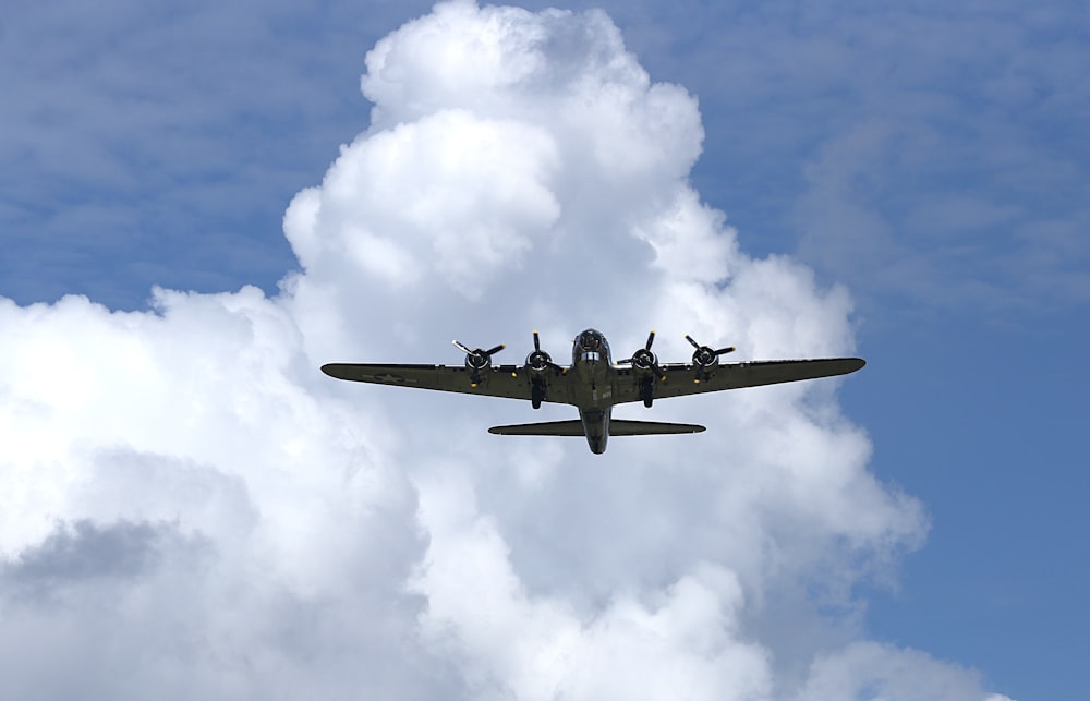 black jet plane flying under white clouds during daytime