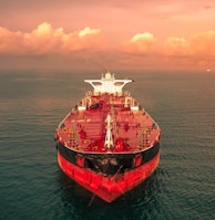 red and white ship on sea under cloudy sky during daytime