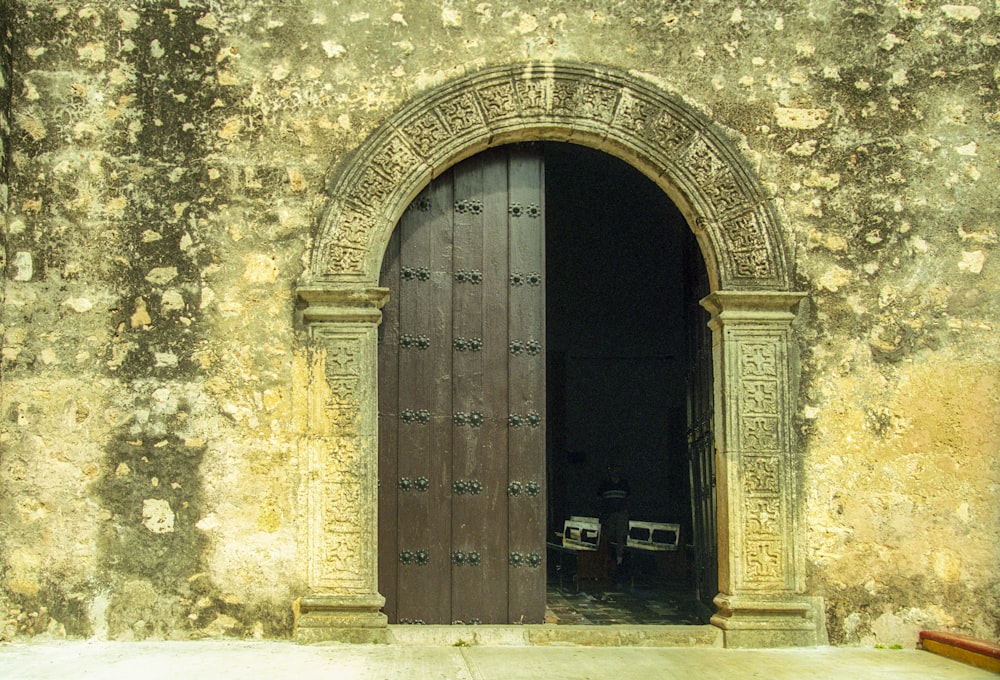 brown wooden door on gray concrete wall