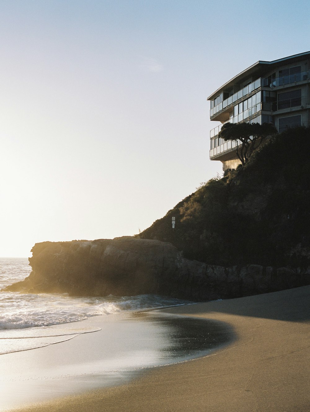 white concrete building on brown sand beach during daytime