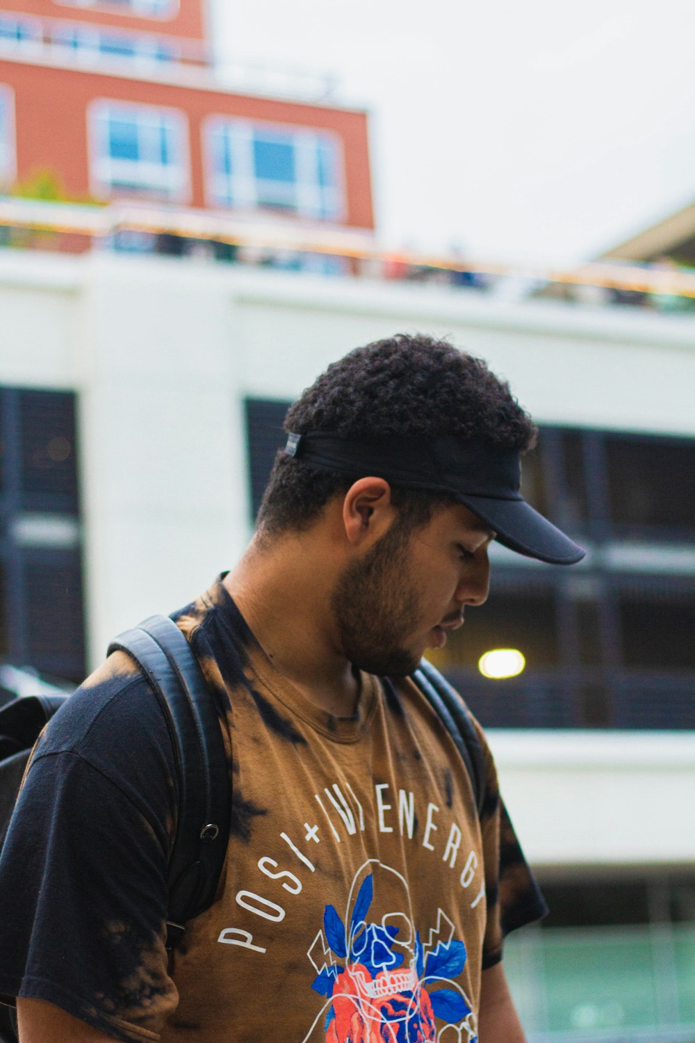 man in black and brown crew neck shirt wearing black cap