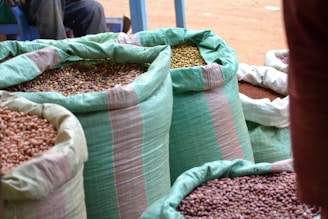 Close-up of fresh pulses spilling from a burlap sack onto a wooden surface.