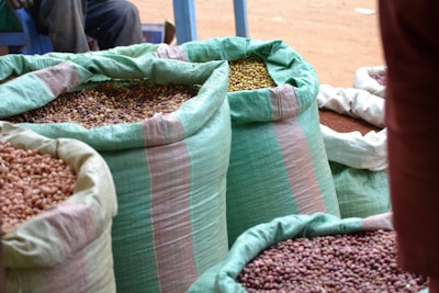 Close-up of fresh pulses spilling from a burlap sack onto a wooden surface.