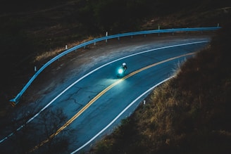 Night ride scene showing a rider cruising a winding road under a starry sky.