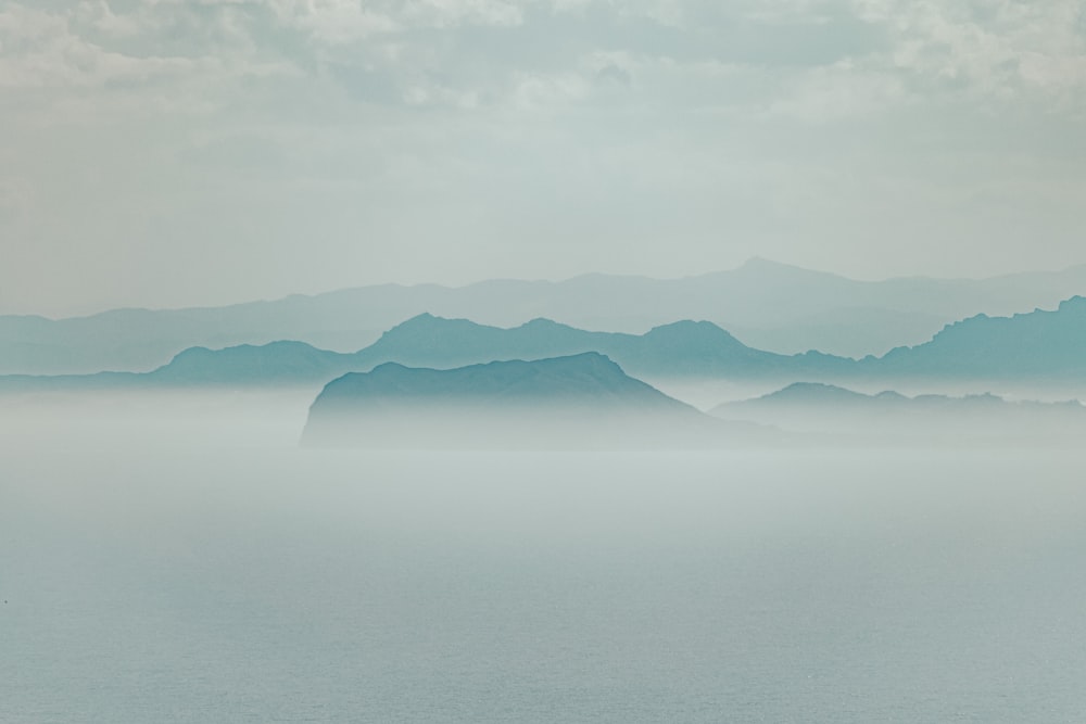 foggy mountain under cloudy sky during daytime