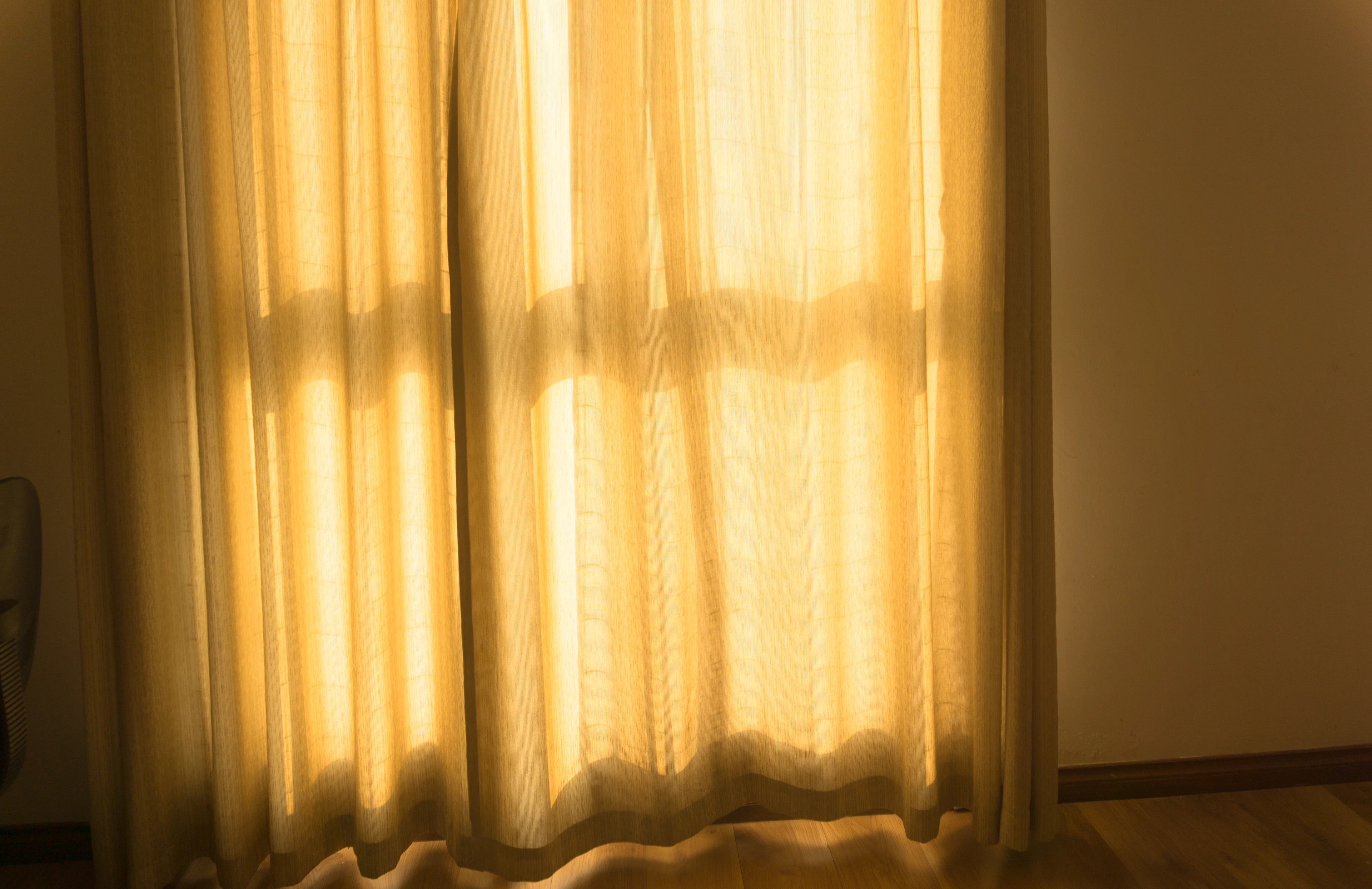 Sunlight glowing through sheer curtains