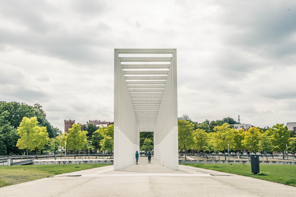 Bâtiment en béton blanc près d’arbres verts sous un ciel blanc pendant la journée