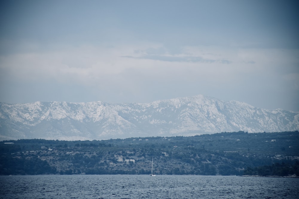 Montagne bianche e nere vicino allo specchio d'acqua durante il giorno