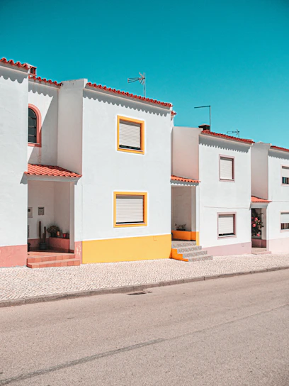 A happy Mexican family standing in front of their new affordable home with a bright blue sky.