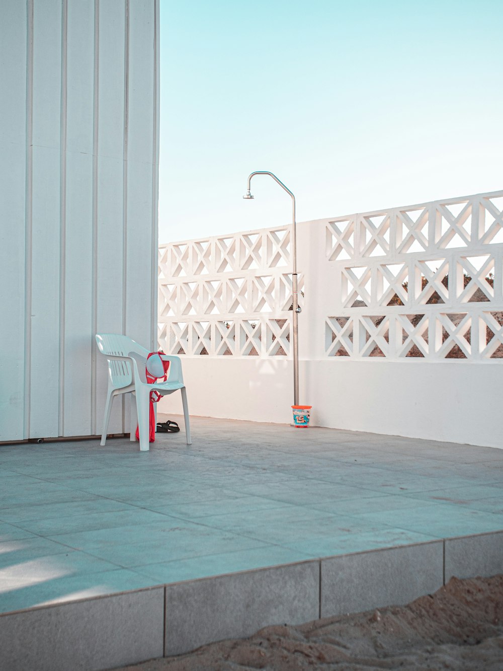 white and red plastic chair beside white wall