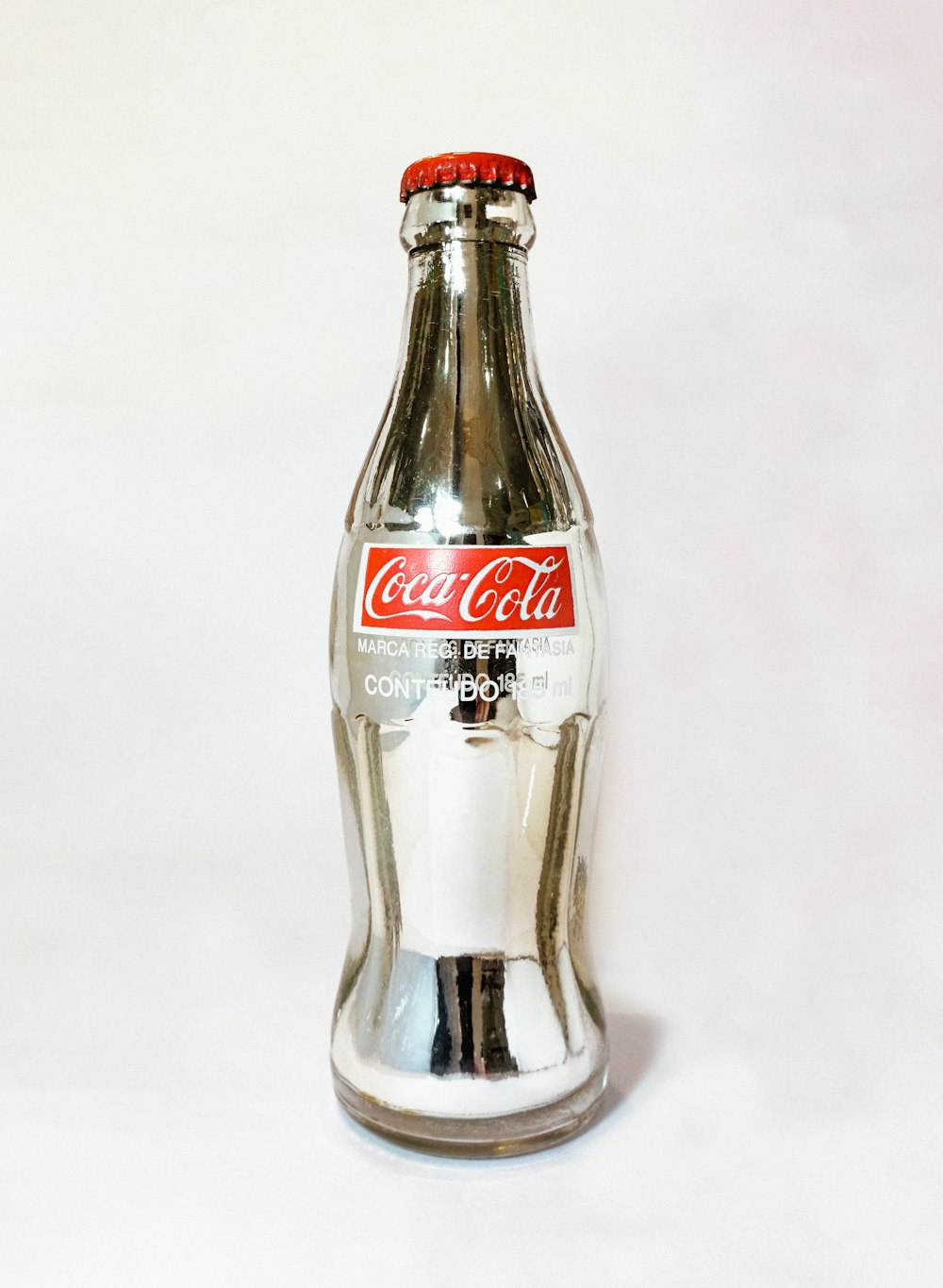 coca cola glass bottle on white table