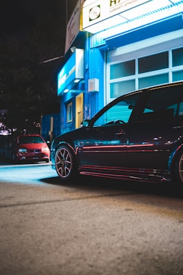 The Wheels Studio storefront bathed in blue and black lighting during dusk, ready for a furious night of service.