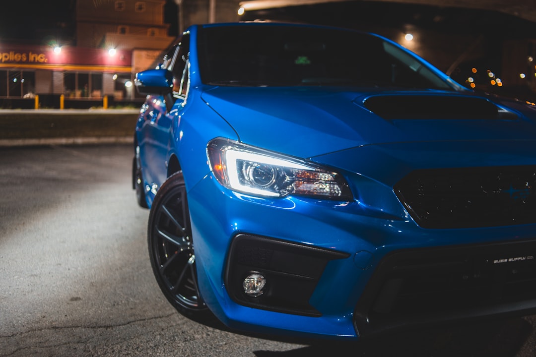 blue car on gray asphalt road during night time