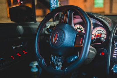 Interior shot showing a custom steering wheel and dashboard with emma performance parts branding glowing softly.