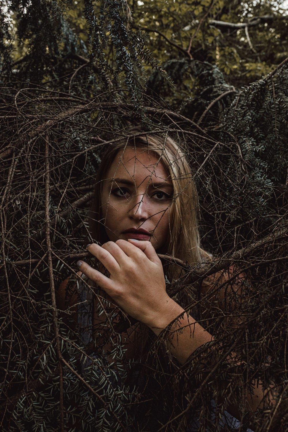 woman in brown long sleeve shirt holding her face