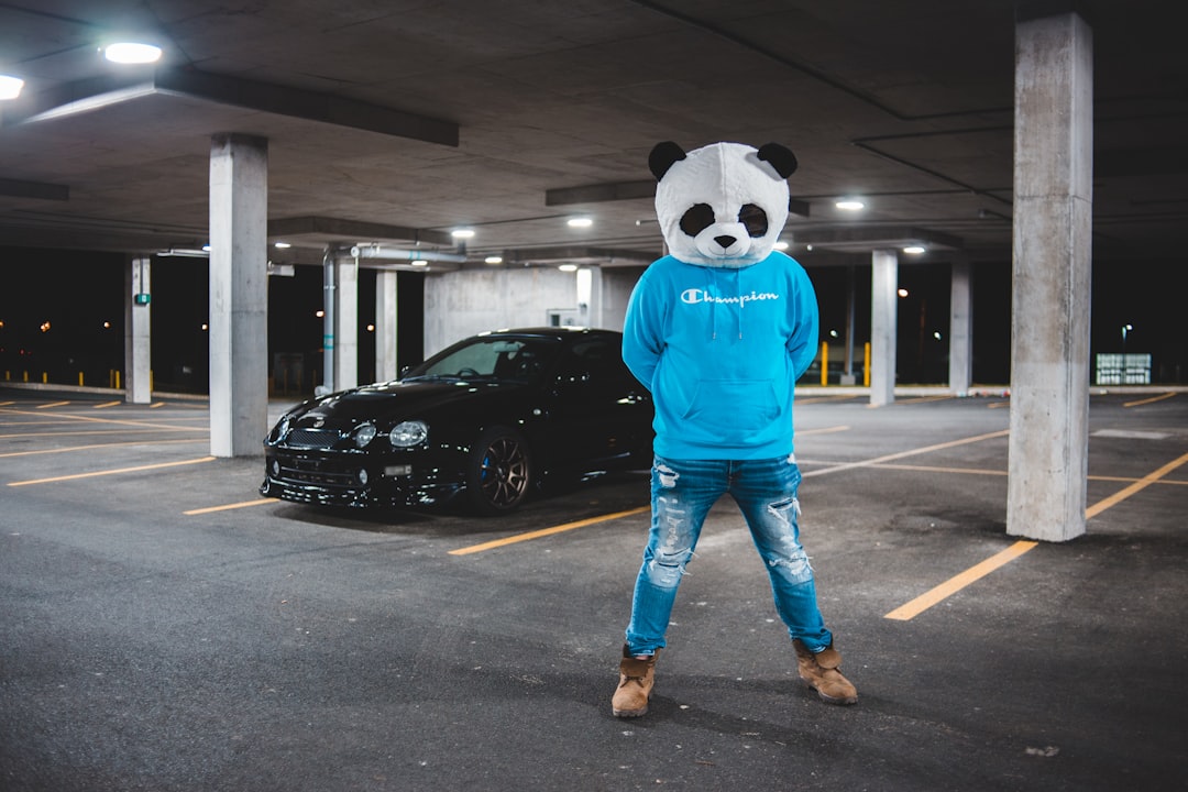 person in blue and white panda costume standing on gray concrete floor