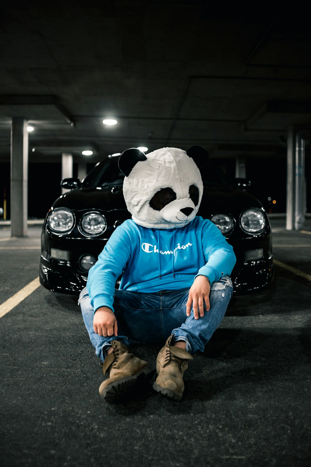 person in blue and white panda costume sitting on black car