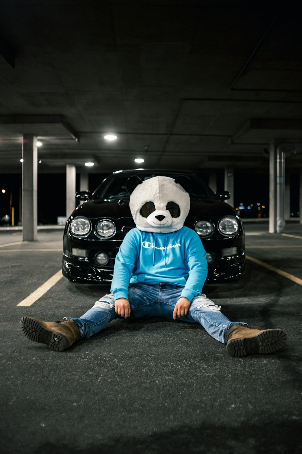 person in blue and white panda costume sitting on black car