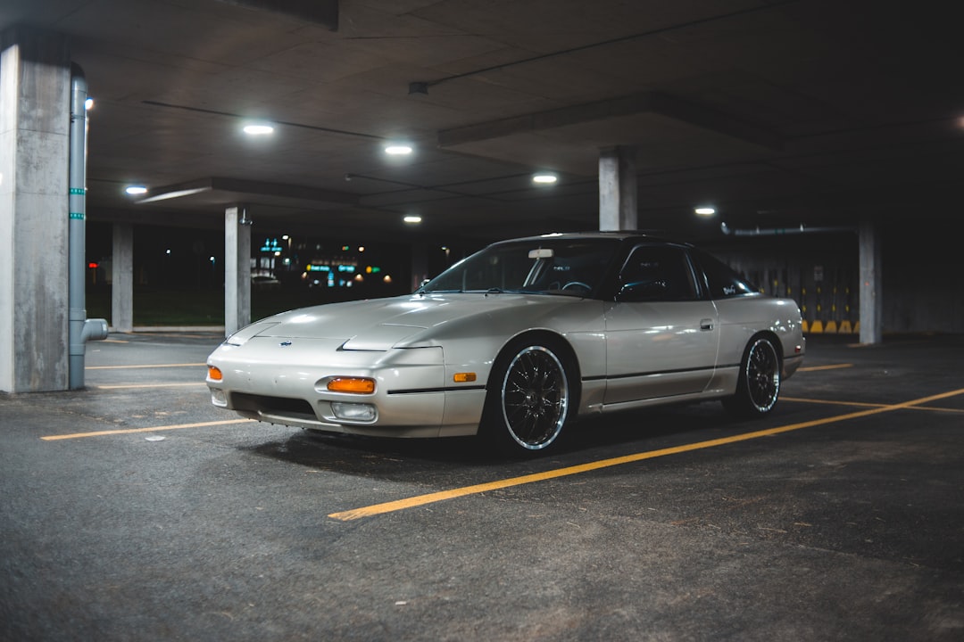 white coupe on parking lot during night time