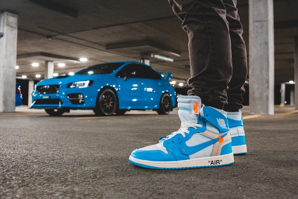 person in blue and white nike air jordan 1 shoes