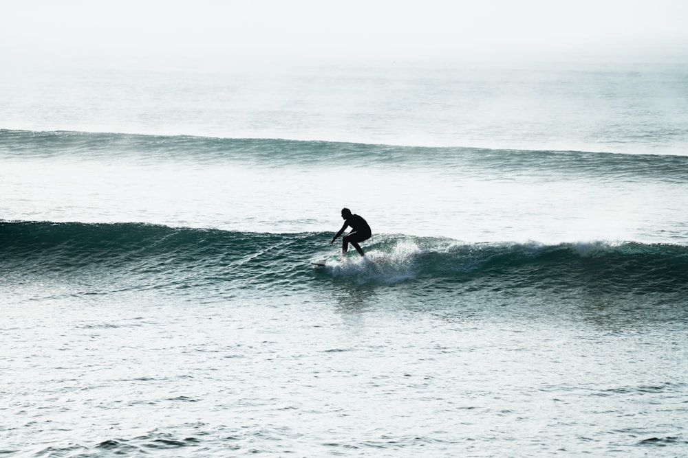 man surfing on sea waves during daytime