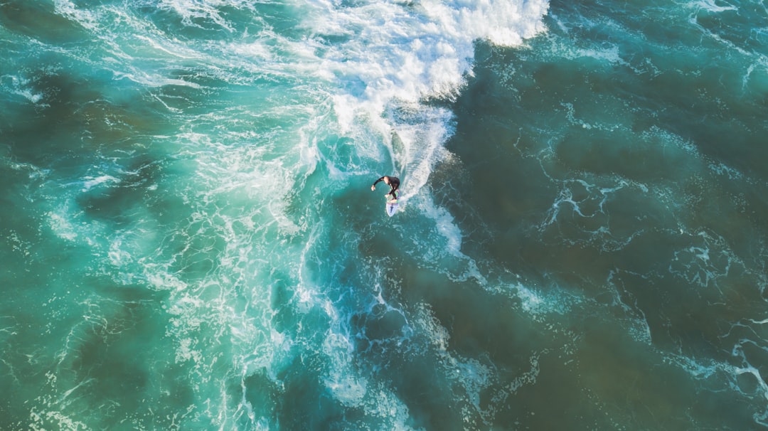 person surfing on sea waves during daytime