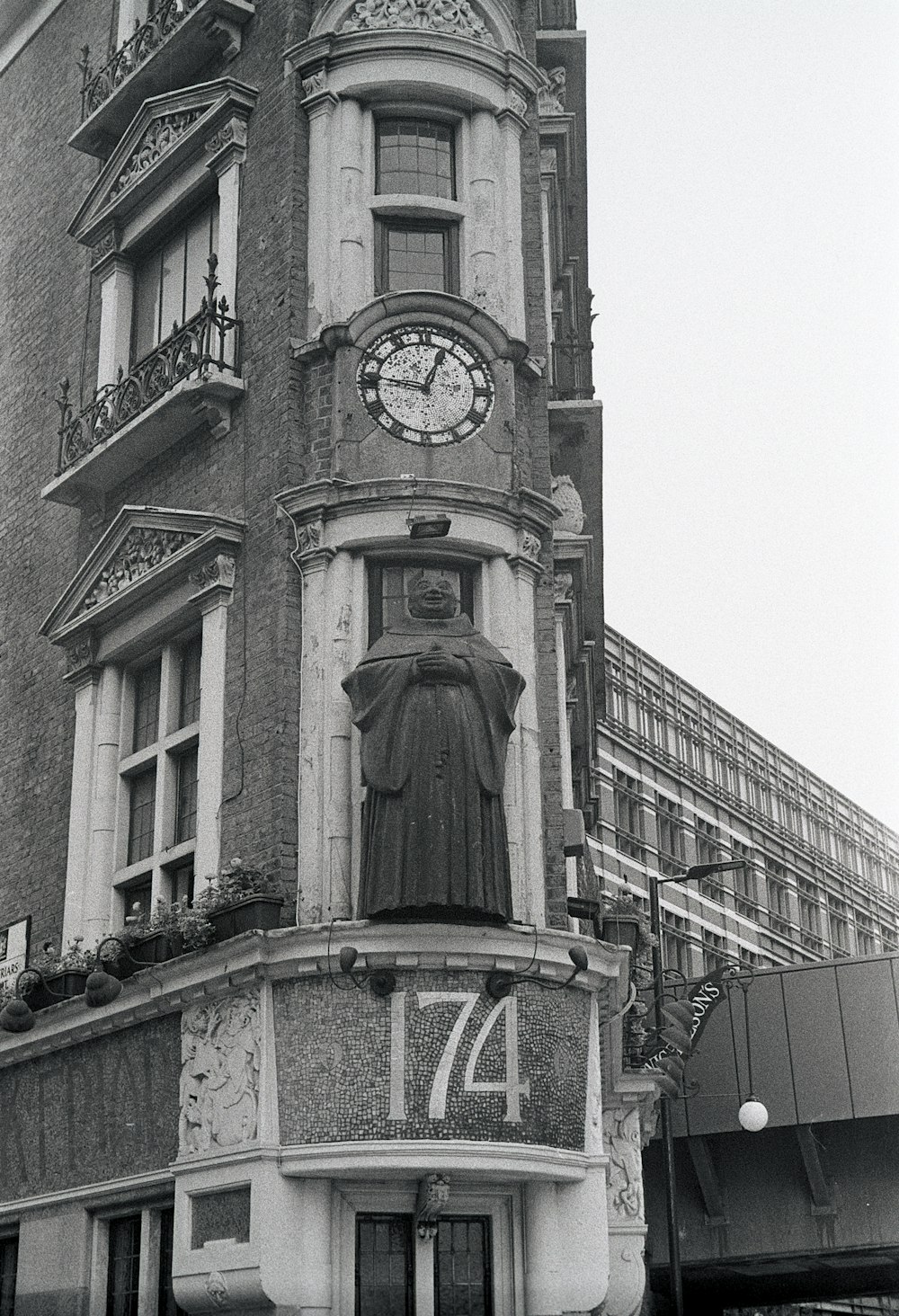 grayscale photo of concrete building with clock