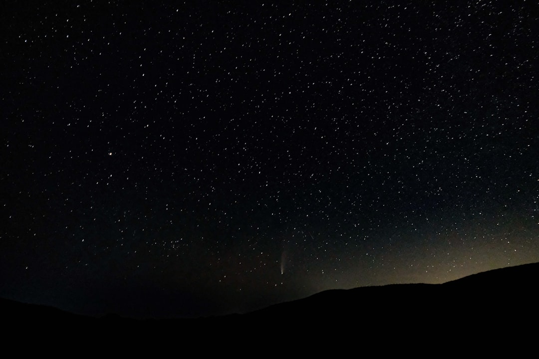 silhouette of mountain under starry night