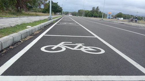 A freshly paved urban road with clear lane markings under a bright sky.