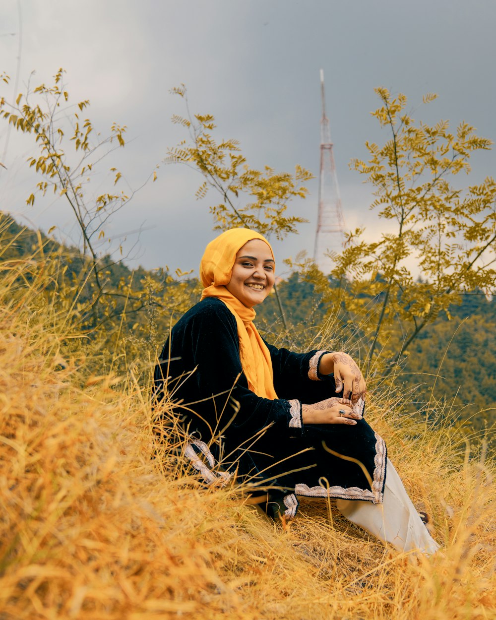 woman in black long sleeve shirt sitting on brown grass field during daytime