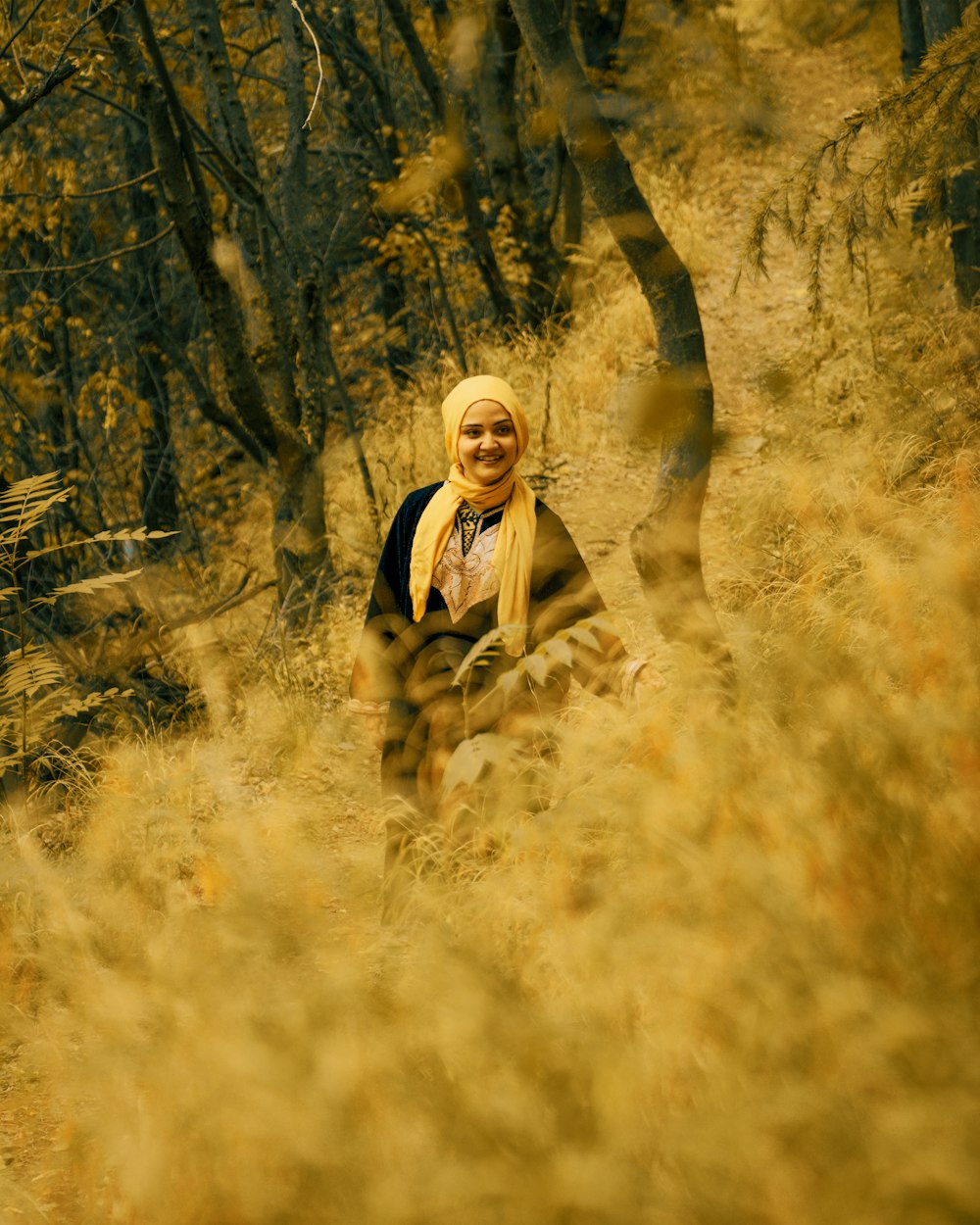Mujer en chaqueta negra de pie en el campo de hierba marrón
